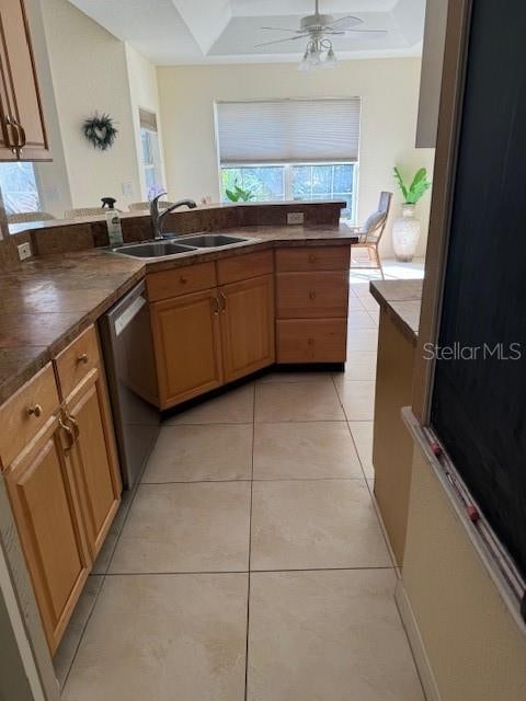 kitchen with sink, stainless steel dishwasher, ceiling fan, light tile patterned floors, and kitchen peninsula