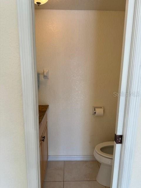 bathroom featuring tile patterned floors, vanity, and toilet