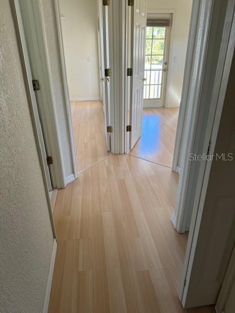 corridor with light hardwood / wood-style flooring