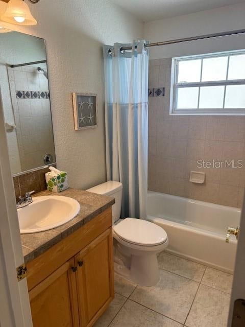 full bathroom with tile patterned floors, vanity, shower / tub combo, and toilet