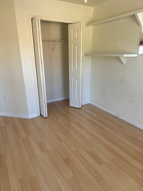 unfurnished bedroom featuring a closet and light wood-type flooring