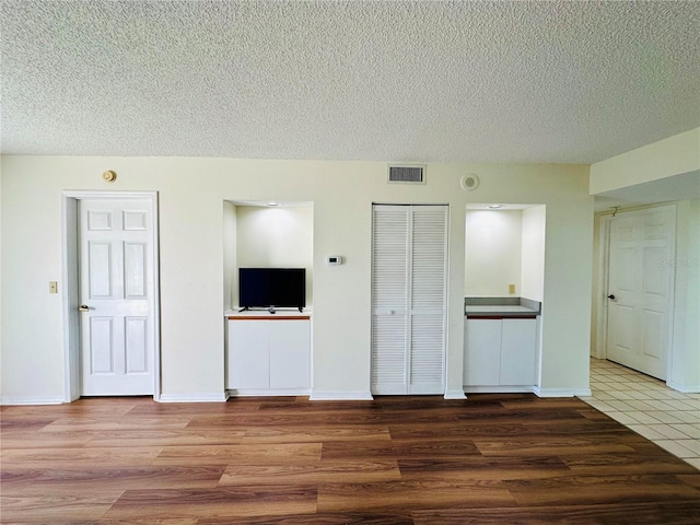 interior space featuring wood-type flooring and a textured ceiling