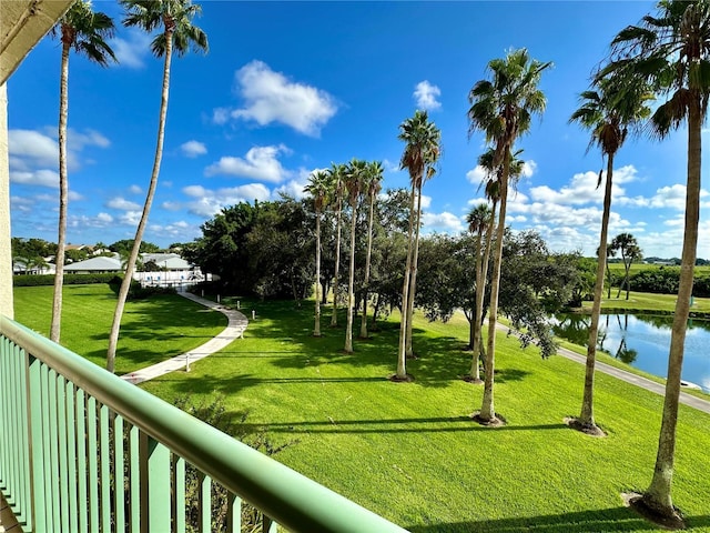 view of home's community with a water view and a lawn