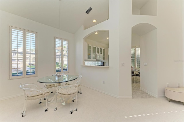 carpeted dining room with lofted ceiling