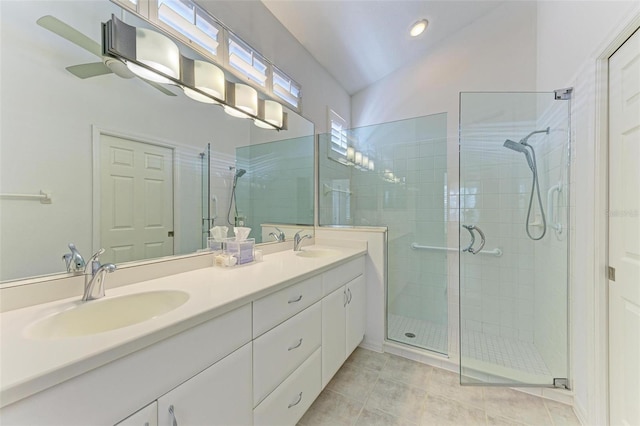 bathroom with tile patterned floors, vanity, a shower with shower door, and lofted ceiling