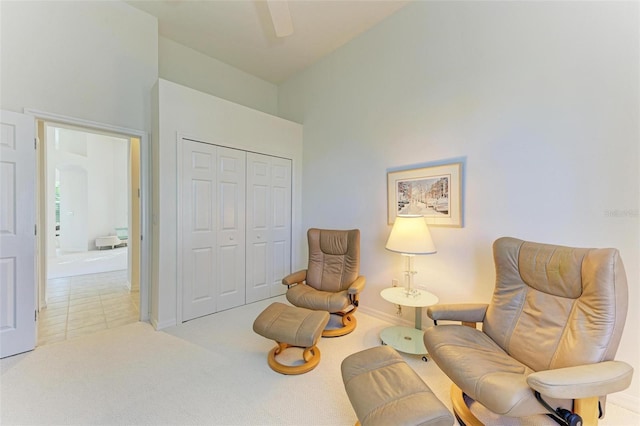 sitting room with ceiling fan and light colored carpet