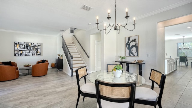 dining area featuring light wood-type flooring, an inviting chandelier, crown molding, and sink