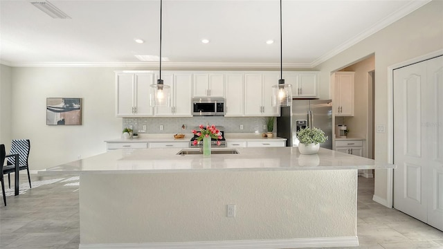 kitchen featuring a center island with sink, stainless steel appliances, and decorative light fixtures