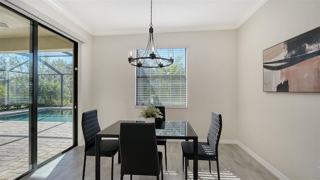 dining area featuring light hardwood / wood-style floors, crown molding, and a notable chandelier