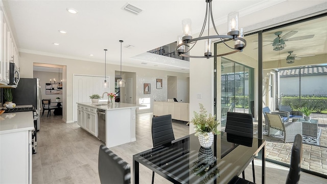 dining room with crown molding, sink, and ceiling fan with notable chandelier