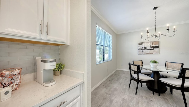 dining space with a notable chandelier, crown molding, and light hardwood / wood-style flooring