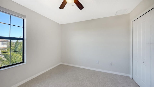 empty room with plenty of natural light, ceiling fan, and light colored carpet