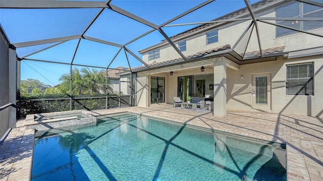 view of pool featuring an in ground hot tub, glass enclosure, ceiling fan, and a patio area