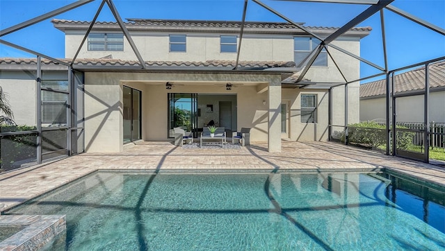 view of pool with outdoor lounge area, glass enclosure, ceiling fan, and a patio area