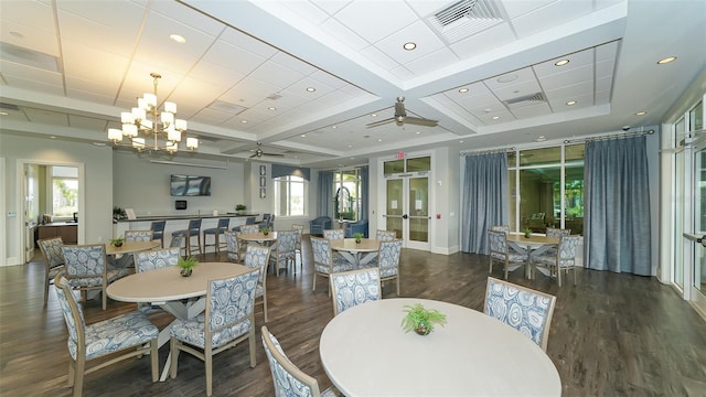 dining space featuring french doors, coffered ceiling, ceiling fan with notable chandelier, dark wood-type flooring, and beam ceiling