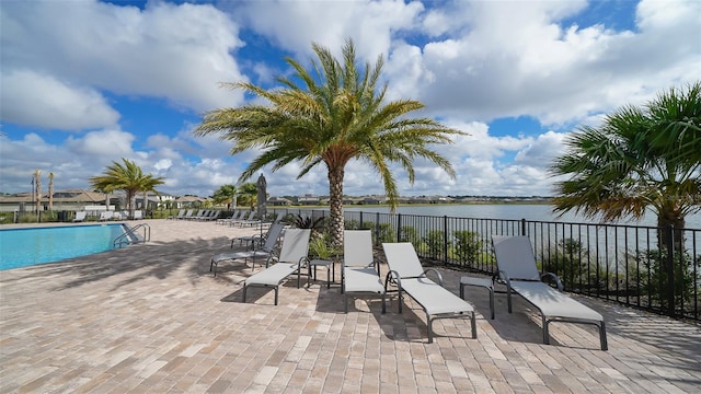 view of patio with a water view and a community pool