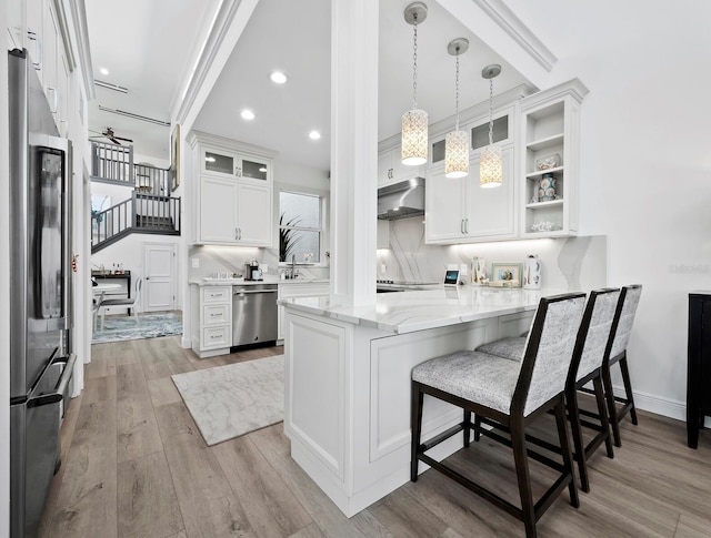 kitchen with kitchen peninsula, white cabinetry, pendant lighting, and appliances with stainless steel finishes