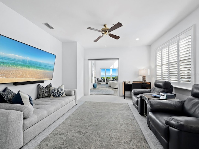 carpeted living room with ceiling fan