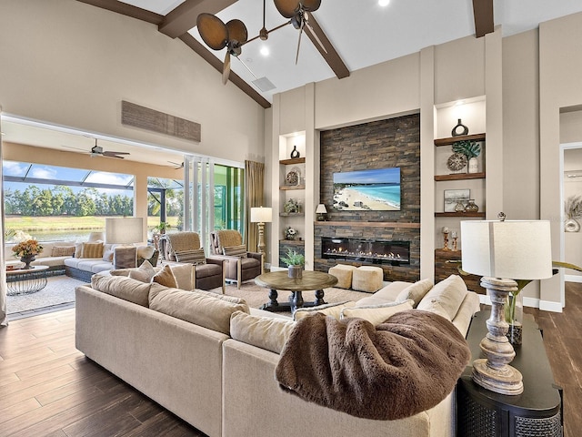 living room with dark hardwood / wood-style flooring, a fireplace, built in shelves, ceiling fan, and beamed ceiling