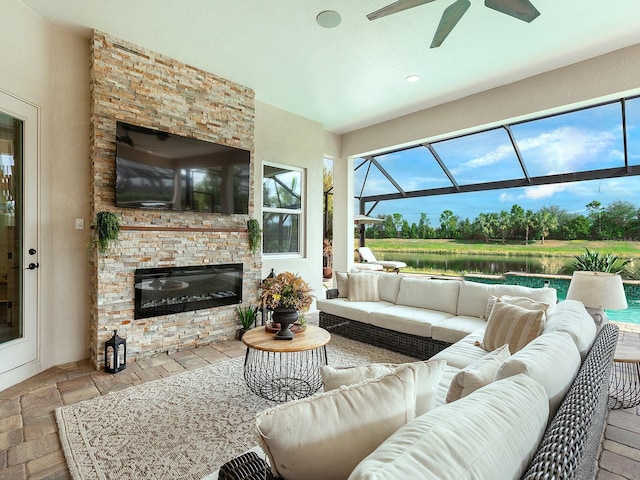 living room with ceiling fan and a stone fireplace