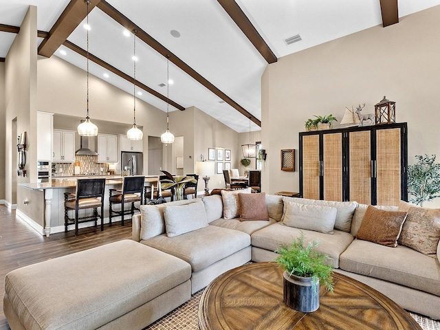 living room featuring beamed ceiling, a towering ceiling, and dark wood-type flooring