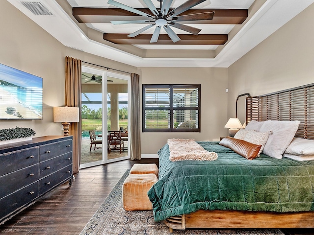 bedroom featuring ceiling fan, dark hardwood / wood-style flooring, access to exterior, and a tray ceiling