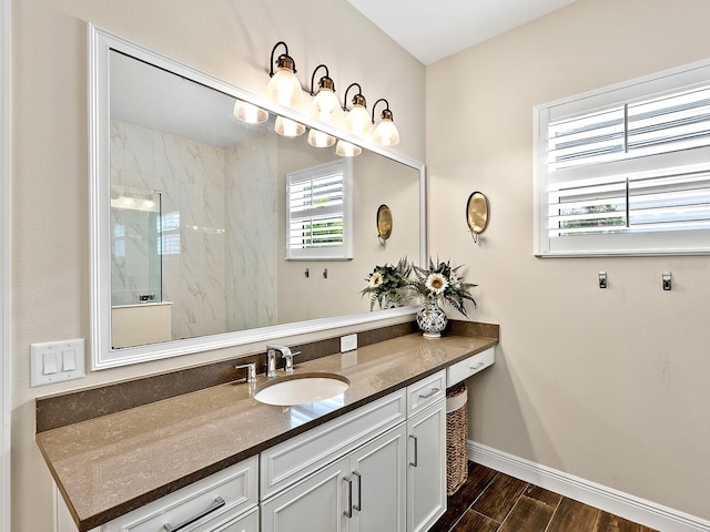 bathroom featuring a tile shower, vanity, and plenty of natural light