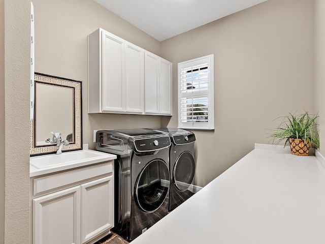 laundry room featuring cabinets, independent washer and dryer, and sink