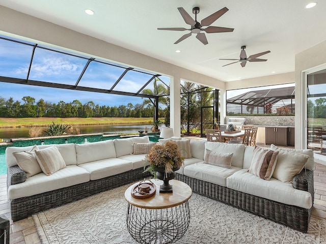 sunroom / solarium with a water view, plenty of natural light, and ceiling fan