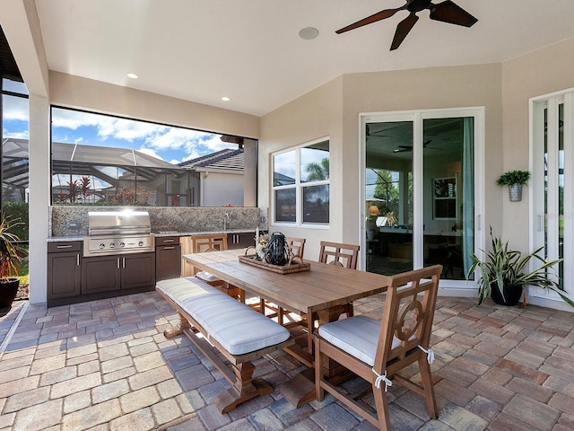 view of patio with glass enclosure, ceiling fan, sink, grilling area, and area for grilling