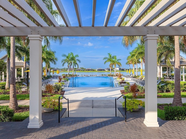 view of swimming pool with a pergola and a water view