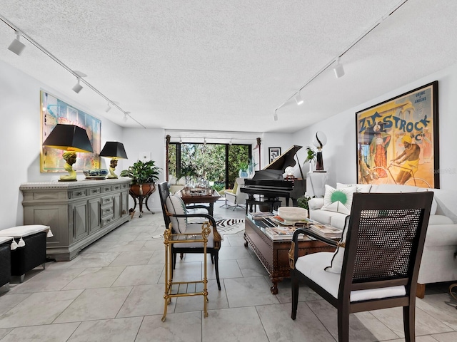 living room with light tile patterned floors, rail lighting, and a textured ceiling