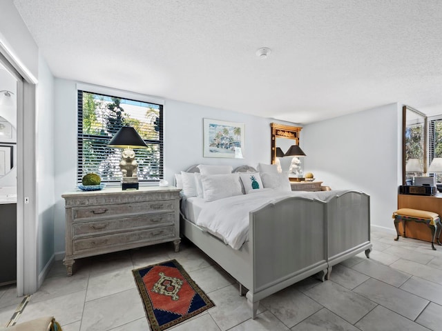 tiled bedroom featuring a textured ceiling and multiple windows