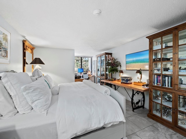 bedroom with light tile patterned floors and a textured ceiling