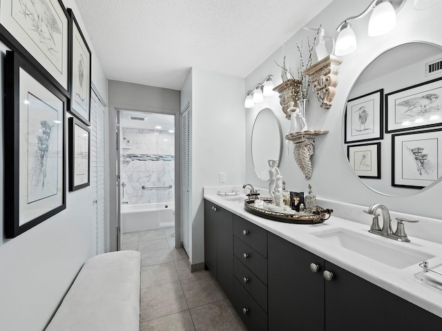 bathroom featuring tile patterned floors, vanity, a textured ceiling, and tiled shower / bath combo