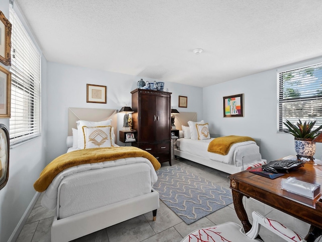 bedroom featuring light tile patterned floors and a textured ceiling