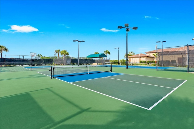 view of tennis court featuring basketball hoop