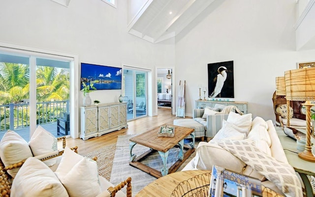 living room featuring beamed ceiling, wood-type flooring, high vaulted ceiling, and a wealth of natural light