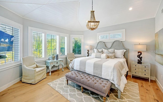 bedroom featuring light hardwood / wood-style floors, wooden ceiling, and an inviting chandelier