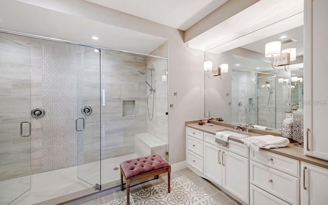 bathroom with tile patterned flooring, vanity, and walk in shower