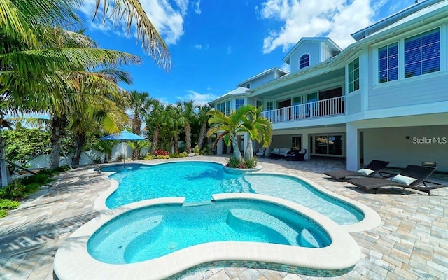 view of swimming pool with a patio area and an in ground hot tub