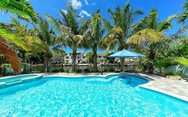 view of swimming pool with a water view and an in ground hot tub