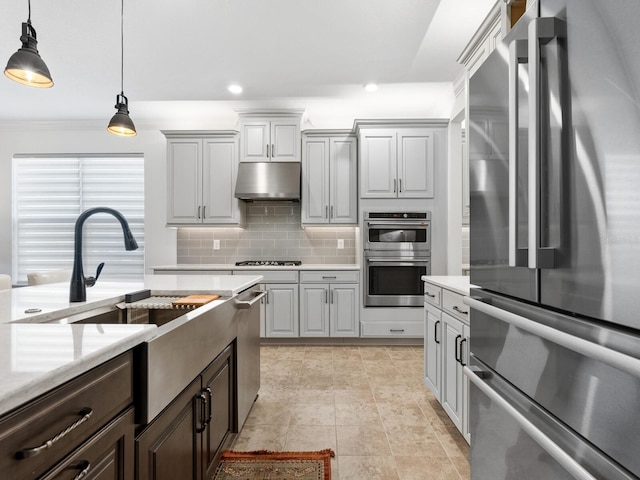 kitchen with decorative backsplash, appliances with stainless steel finishes, crown molding, decorative light fixtures, and gray cabinets