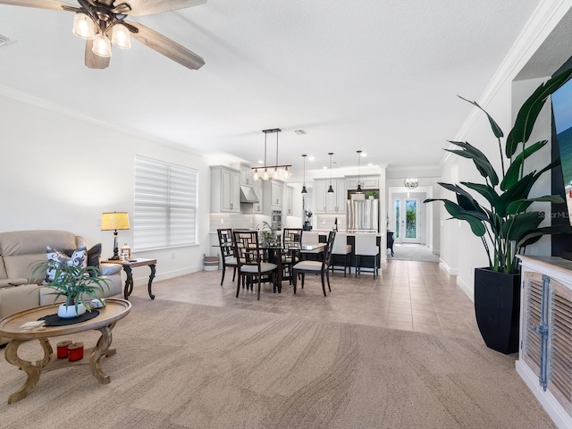 dining area featuring ceiling fan, ornamental molding, and light carpet