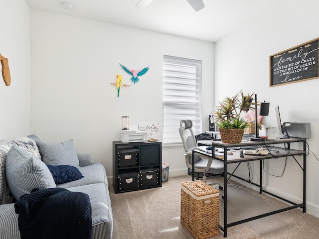 carpeted home office featuring ceiling fan