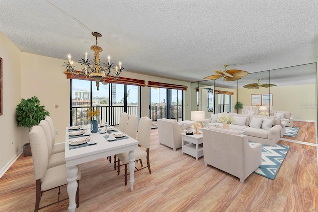 living room with a textured ceiling, ceiling fan with notable chandelier, and light wood-type flooring