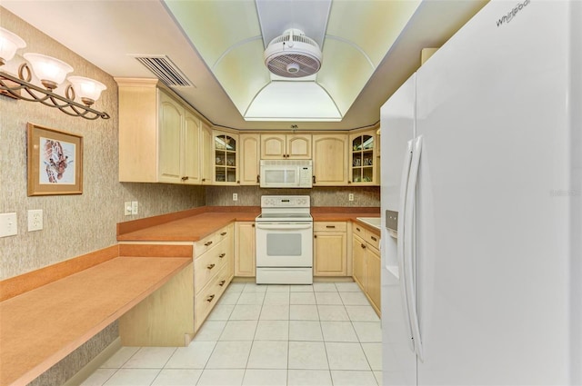 kitchen featuring light brown cabinets, white appliances, and light tile patterned floors