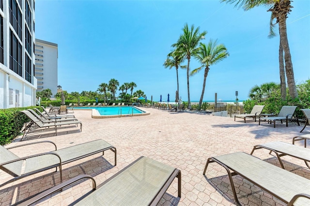 view of pool with a patio area and a water view