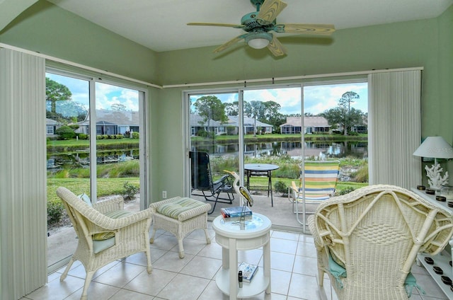 sunroom featuring a water view and ceiling fan