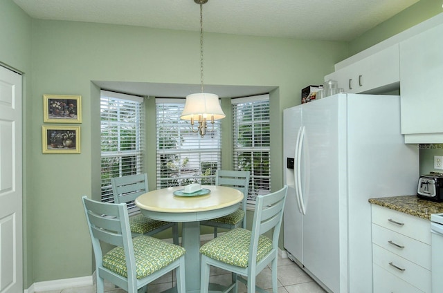 tiled dining area with a textured ceiling and vaulted ceiling